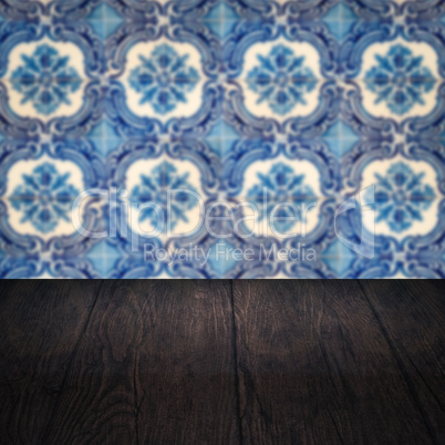 Wood table top and blur vintage ceramic tile pattern wall