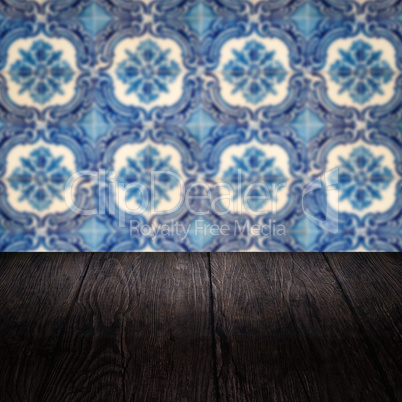 Wood table top and blur vintage ceramic tile pattern wall