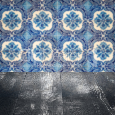 Wood table top and blur vintage ceramic tile pattern wall