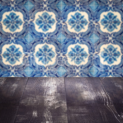 Wood table top and blur vintage ceramic tile pattern wall