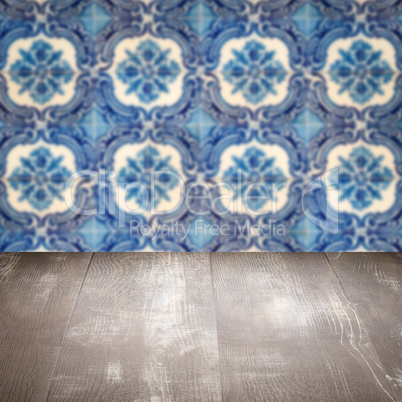 Wood table top and blur vintage ceramic tile pattern wall