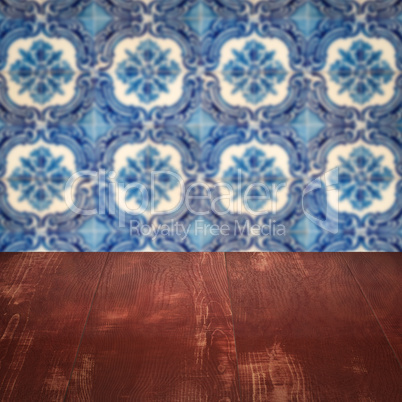 Wood table top and blur vintage ceramic tile pattern wall Wood table top and blur vintage ceramic tile pattern wall