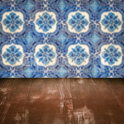 Wood table top and blur vintage ceramic tile pattern wall Wood table top and blur vintage ceramic tile pattern wall