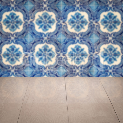 Wood table top and blur vintage ceramic tile pattern wall