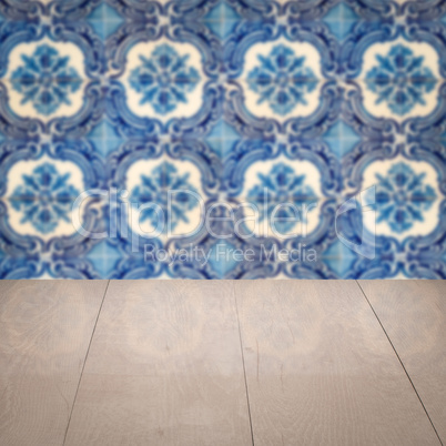 Wood table top and blur vintage ceramic tile pattern wall