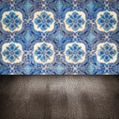 Wood table top and blur vintage ceramic tile pattern wall Wood table top and blur vintage ceramic tile pattern wall