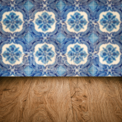 Wood table top and blur vintage ceramic tile pattern wall