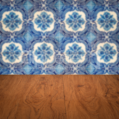 Wood table top and blur vintage ceramic tile pattern wall