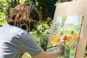 Frau beim Malen mit Pinseln, woman painting with paint brush