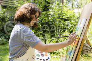 Frau beim Malen mit Pinseln, woman painting with paint brush