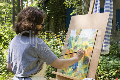 Frau beim Malen mit Pinseln, woman painting with paint brush