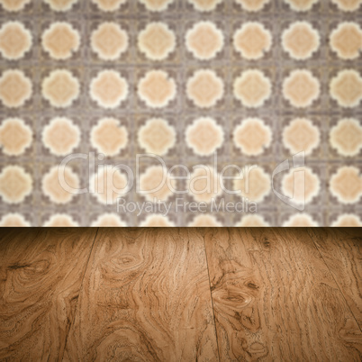 Wood table top and blur vintage ceramic tile pattern wall