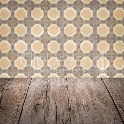 Wood table top and blur vintage ceramic tile pattern wall Wood table top and blur vintage ceramic tile pattern wall