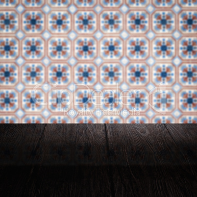 Wood table top and blur vintage ceramic tile pattern wall