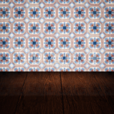 Wood table top and blur vintage ceramic tile pattern wall