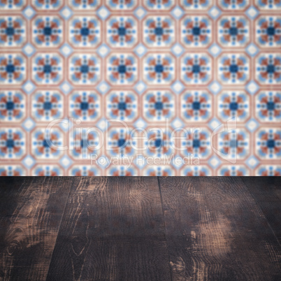 Wood table top and blur vintage ceramic tile pattern wall