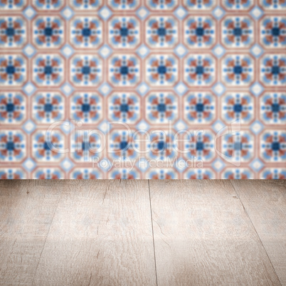 Wood table top and blur vintage ceramic tile pattern wall