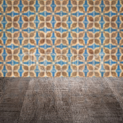 Wood table top and blur vintage ceramic tile pattern wall