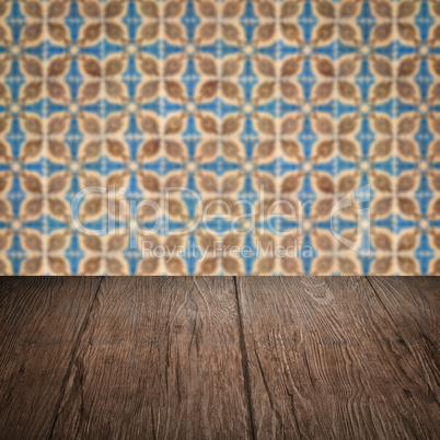 Wood table top and blur vintage ceramic tile pattern wall