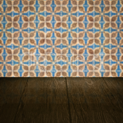 Wood table top and blur vintage ceramic tile pattern wall