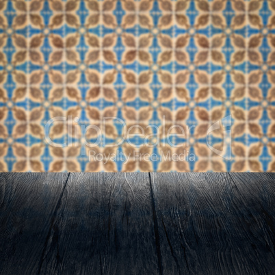 Wood table top and blur vintage ceramic tile pattern wall