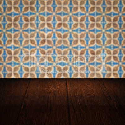 Wood table top and blur vintage ceramic tile pattern wall Wood table top and blur vintage ceramic tile pattern wall