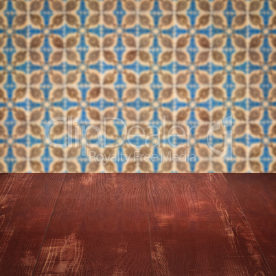 Wood table top and blur vintage ceramic tile pattern wall Wood table top and blur vintage ceramic tile pattern wall