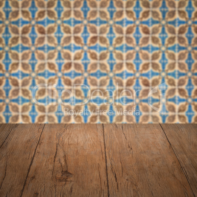 Wood table top and blur vintage ceramic tile pattern wall