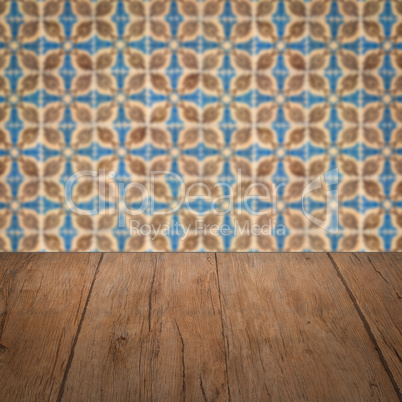 Wood table top and blur vintage ceramic tile pattern wall