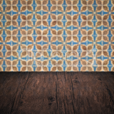 Wood table top and blur vintage ceramic tile pattern wall