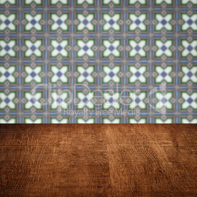 Wood table top and blur vintage ceramic tile pattern wall