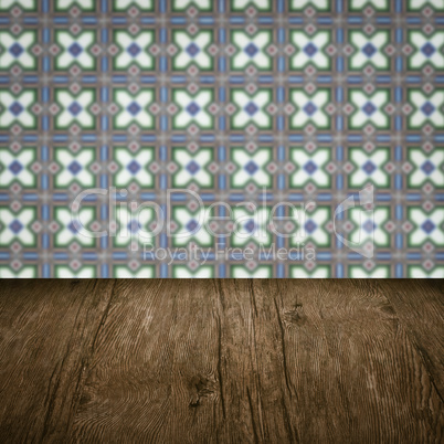 Wood table top and blur vintage ceramic tile pattern wall