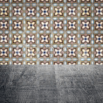 Wood table top and blur vintage ceramic tile pattern wall