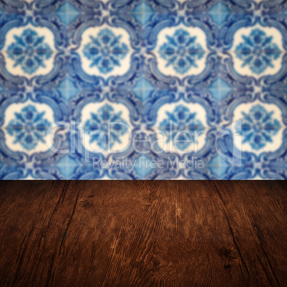 Wood table top and blur vintage ceramic tile pattern wall