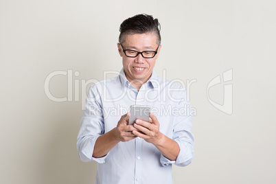 Mature Asian man using smartphone