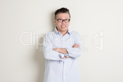 Portrait of mature Asian man arms crossed