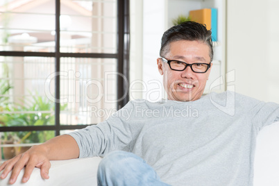 Mature Asian man sitting at home.