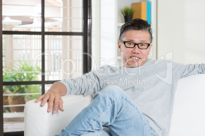 Mature Asian male sitting at home.