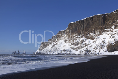 Wide lens capture of the three pinnacles of Vik, Iceland in wint