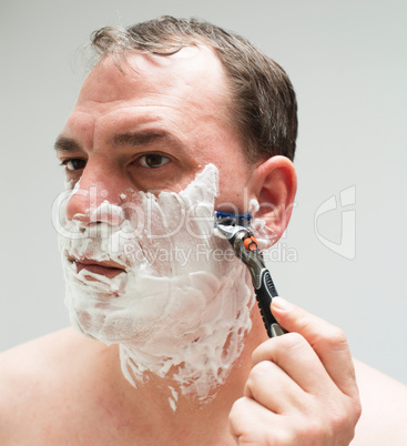 Mann rasiert sich das Gesicht