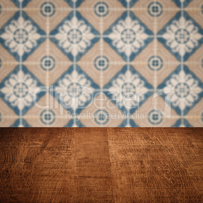 Wood table top and blur vintage ceramic tile pattern wall