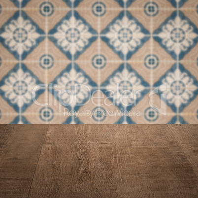 Wood table top and blur vintage ceramic tile pattern wall