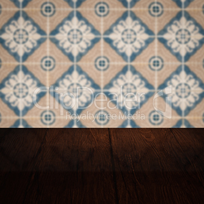 Wood table top and blur vintage ceramic tile pattern wall