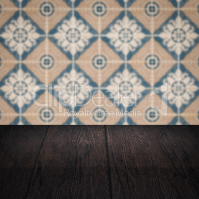 Wood table top and blur vintage ceramic tile pattern wall