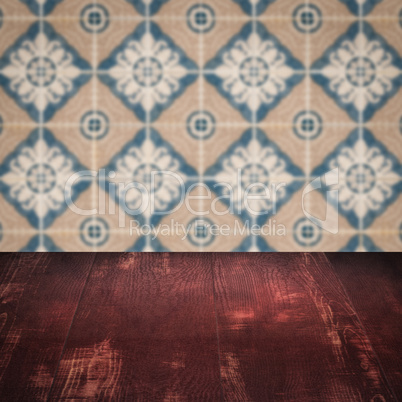 Wood table top and blur vintage ceramic tile pattern wall Wood table top and blur vintage ceramic tile pattern wall
