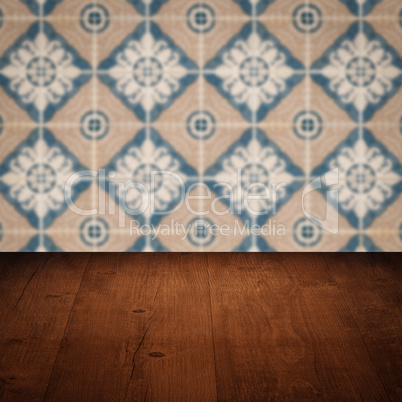 Wood table top and blur vintage ceramic tile pattern wall