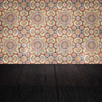 Wood table top and blur vintage ceramic tile pattern wall