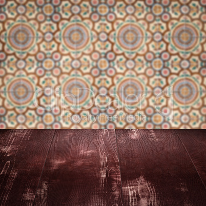 Wood table top and blur vintage ceramic tile pattern wall Wood table top and blur vintage ceramic tile pattern wall