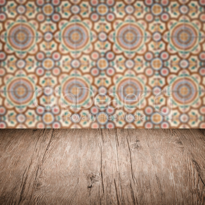 Wood table top and blur vintage ceramic tile pattern wall