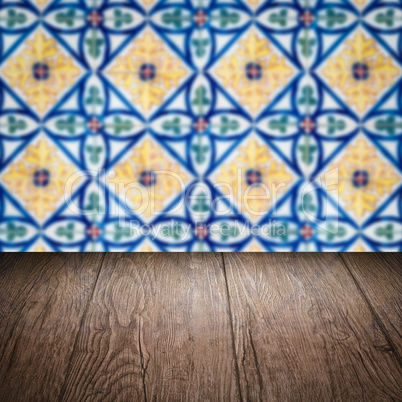 Wood table top and blur vintage ceramic tile pattern wall